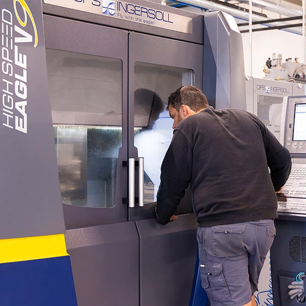 Un fraiseur / programmeur FAO observe l’approche de la fraise sur la pièce. Sur l’OPS Ingersoll V9, des travaux de très haute précision sont réalisés.