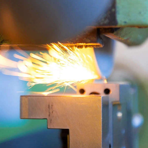 Ein Werkstück wird auf der Schleifmaschine geschliffen. Die Funken sprühen.