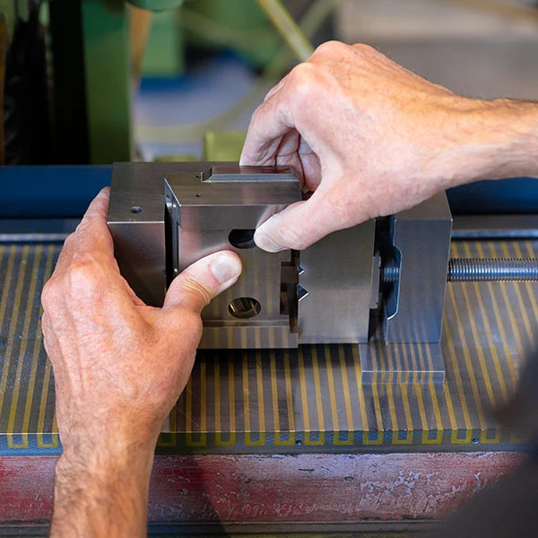 Der Schleifer richtet ein Werkstück auf einer Magnetspannplatte aus.