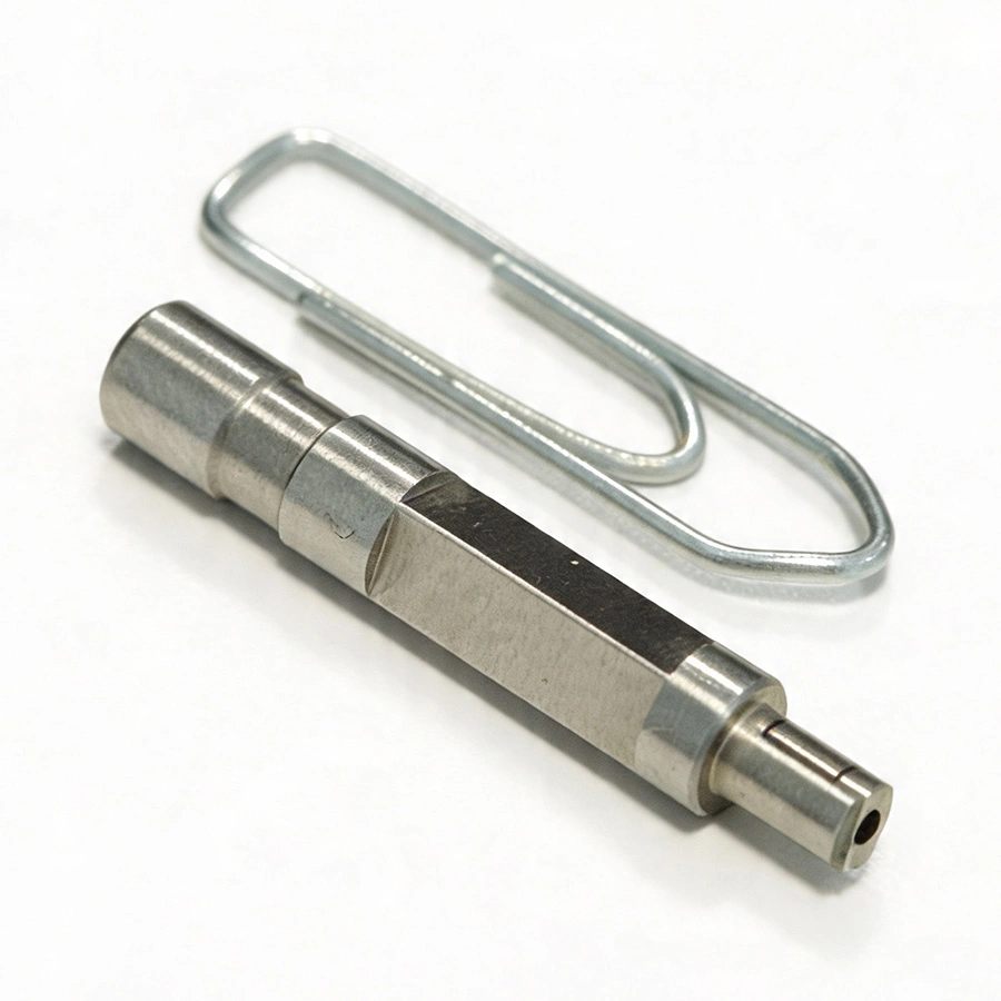 Een fijnmechanisch onderdeel. Een paperclip geeft een goede indicatie van de afmetingen van het onderdeel.