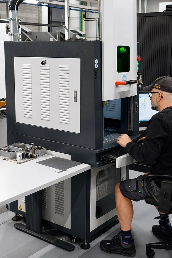 Gravure laser : un opérateur règle la machine pour une nouvelle opération de gravure.