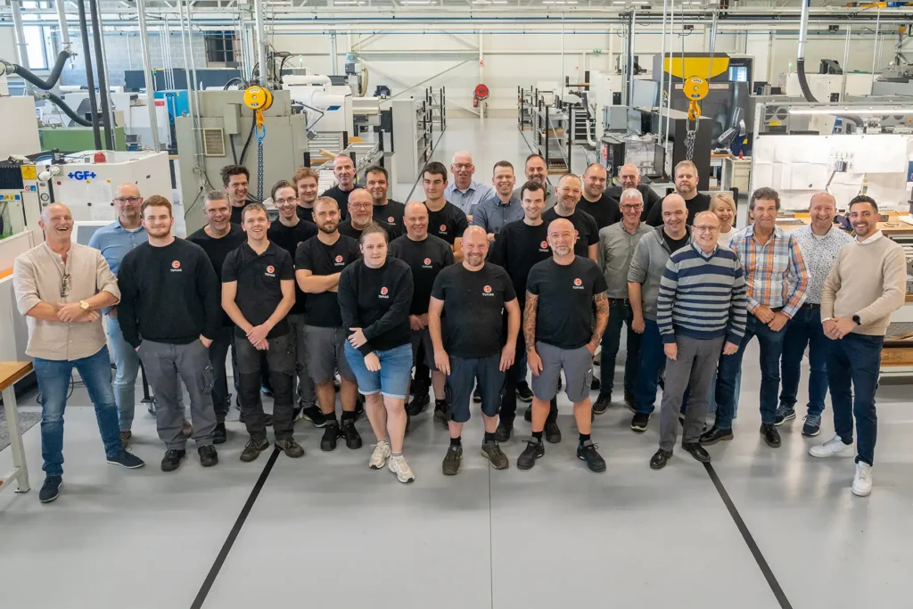 Tumag - Gruppenfoto des Spezialistenteams von Tumag in einer modernen Produktionsumgebung
